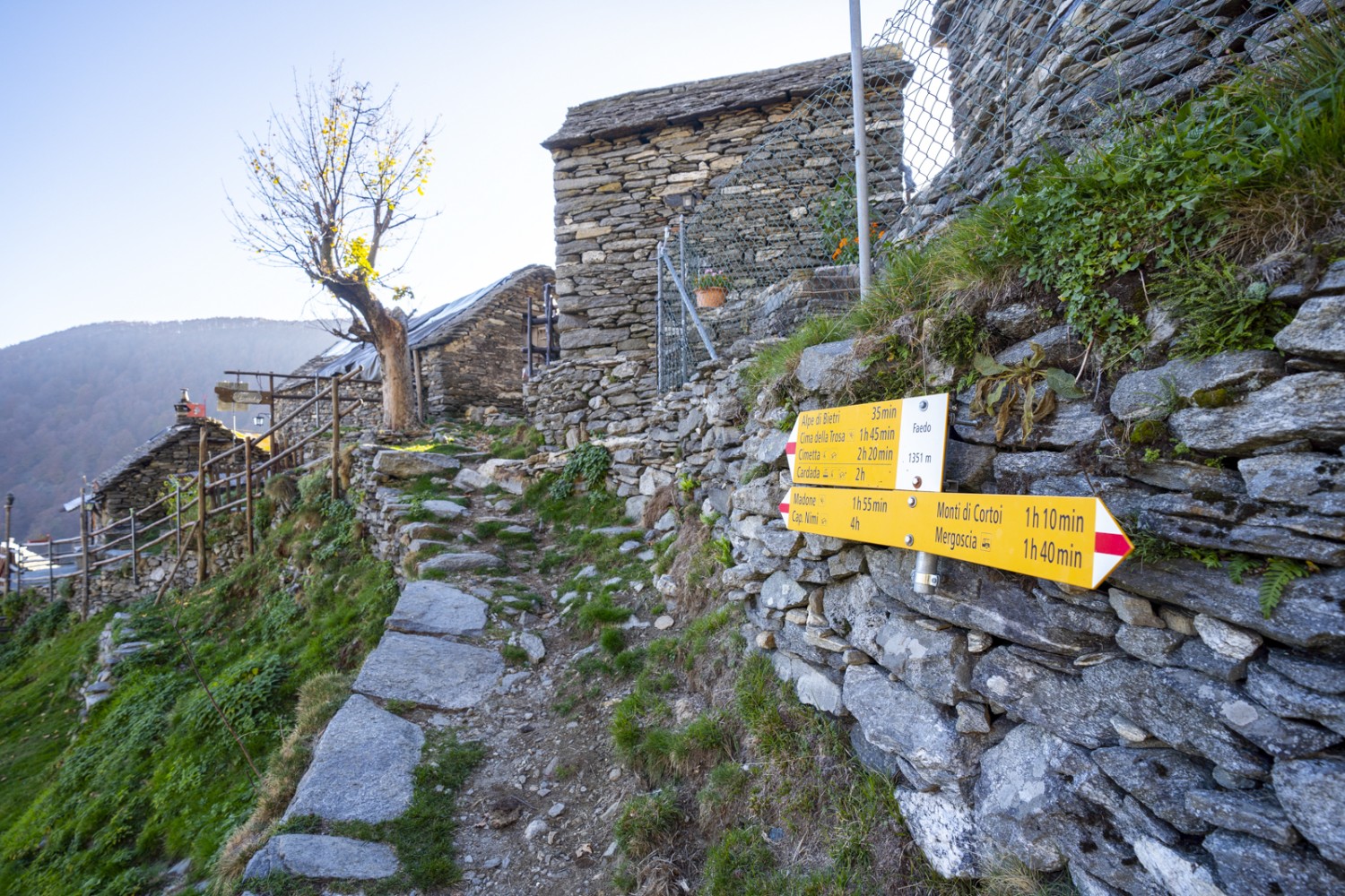 Beim Weiler Faedo; rustikale Steinhäuser und Trockensteinmauern säumen den Weg. Bild: Wanderblondies