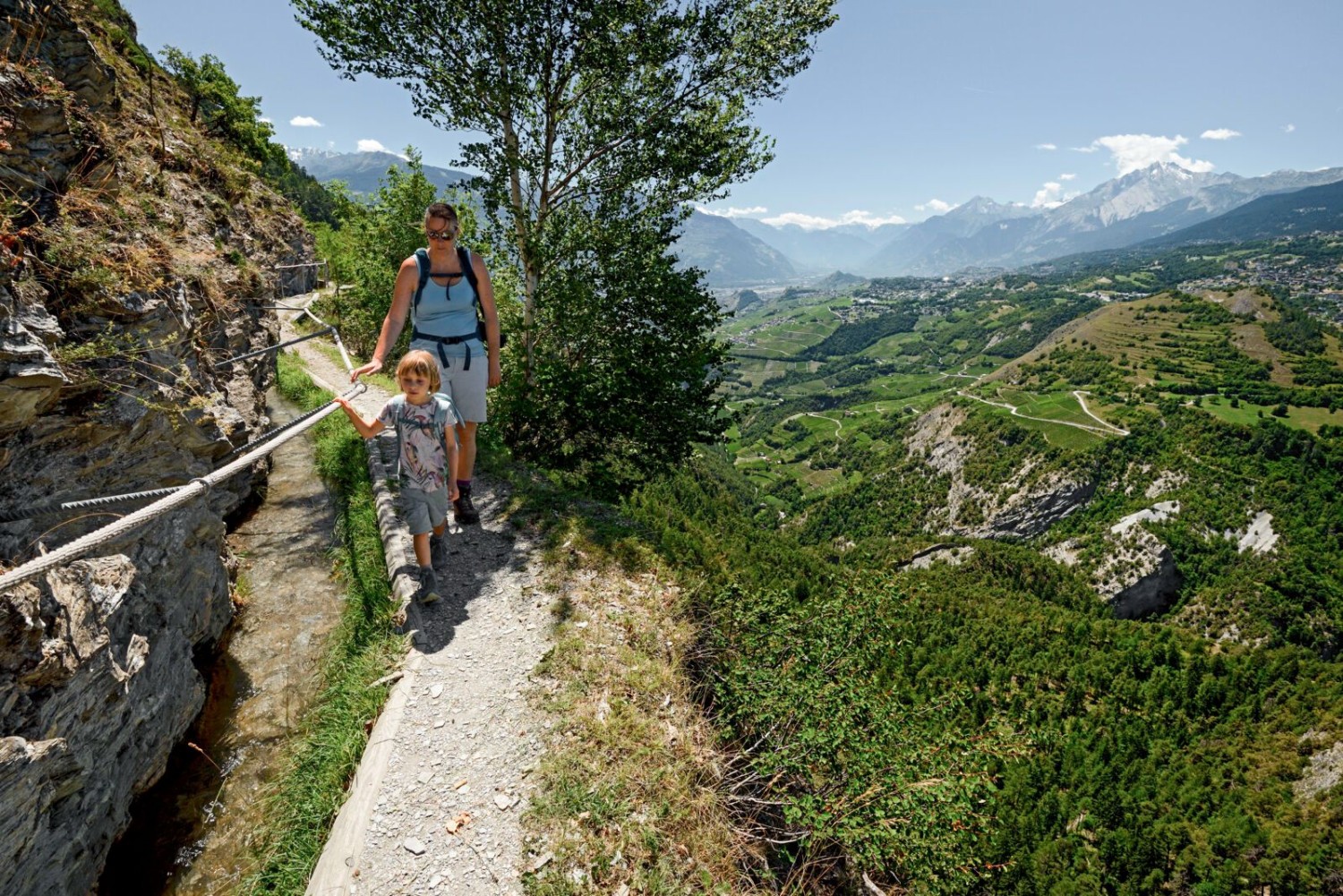Der Grand Bisse de Lens entlang, oberhalb von Rebbergen.