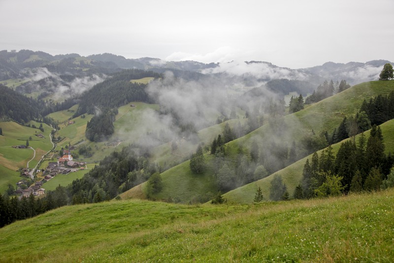 Nebelverhangene Hügel. Unten im Tal das Dörfchen Trub. Bild: Daniel Fuchs